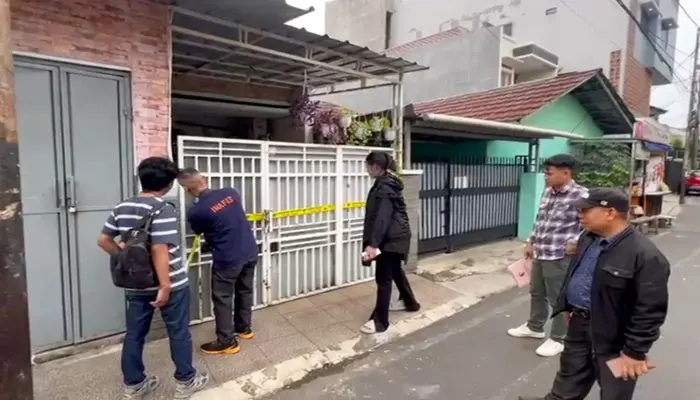 Petugas kepolisian memasang garis polisi di depan rumah yang menjadi lokasi dugaan pencabulan oleh oknum guru mengaji di Kebon Baru, Tebet, Jakarta Selatan.