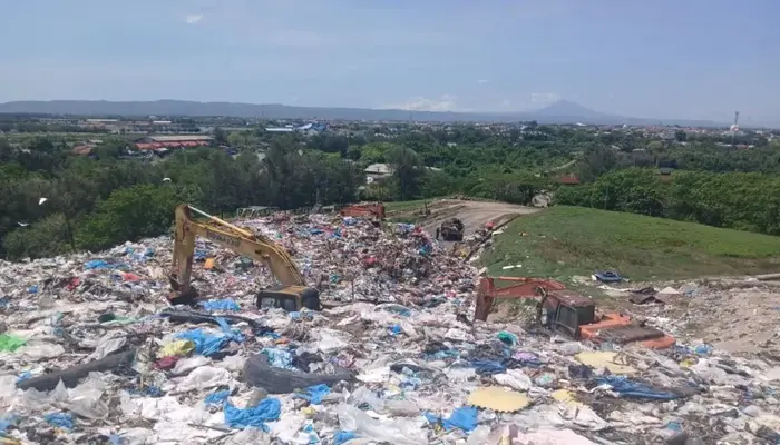 Teknologi Ramah Lingkungan Singapura, Tumpukan sampah besar di Tempat Pembuangan Akhir (TPA) dengan alat berat yang sedang mengolah limbah di Aceh.
