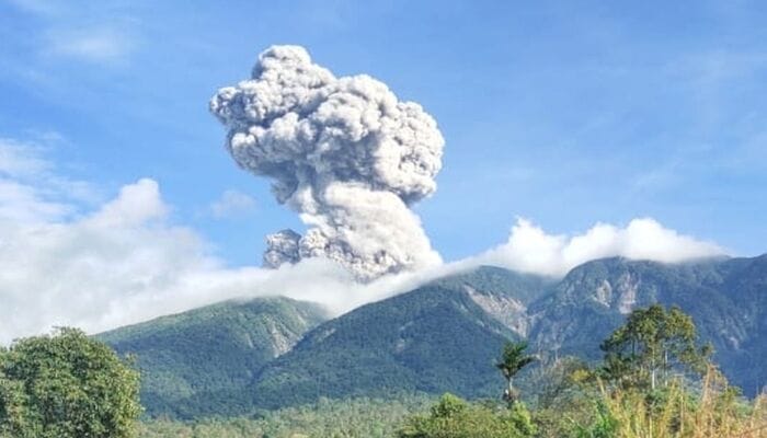 Gunung Marapi Erupsi,Asap tebal berwarna kelabu membumbung tinggi dari puncak Gunung Marapi di Sumatera Barat saat erupsi, terlihat jelas di bawah langit biru.